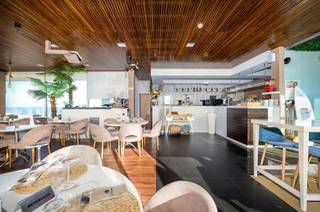 Beachfront beach club and restaurant operating under a licensed maritime concession offering diverse dining options.